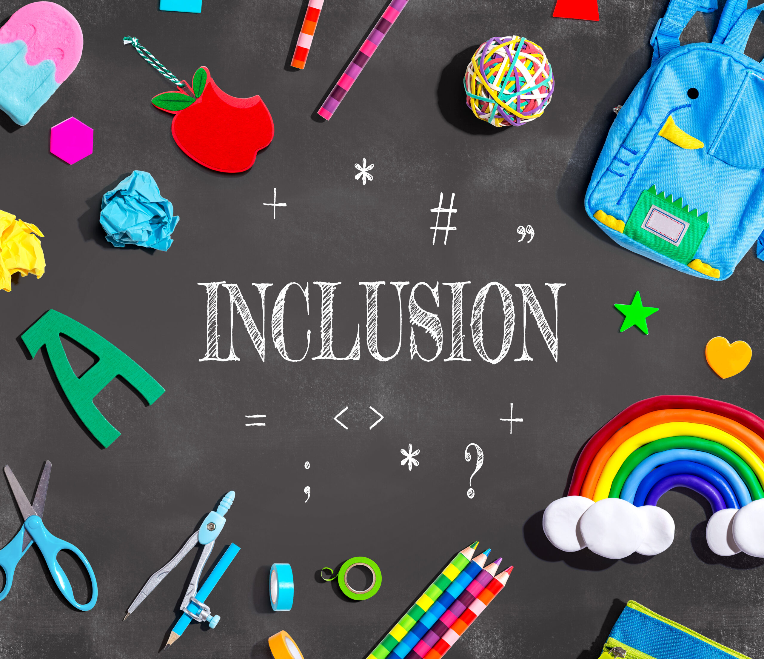 The word “Inclusion” on a chalkboard surrounded by colorful school supplies and a rainbow.